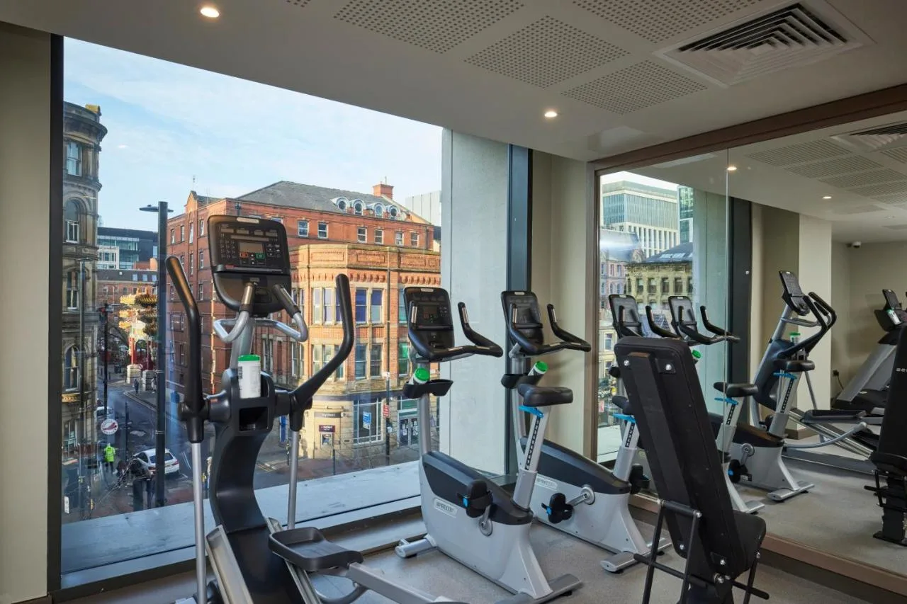 a gym with cardio machines in front of a window at Clayton Hotel Manchester City Centre in Manchester