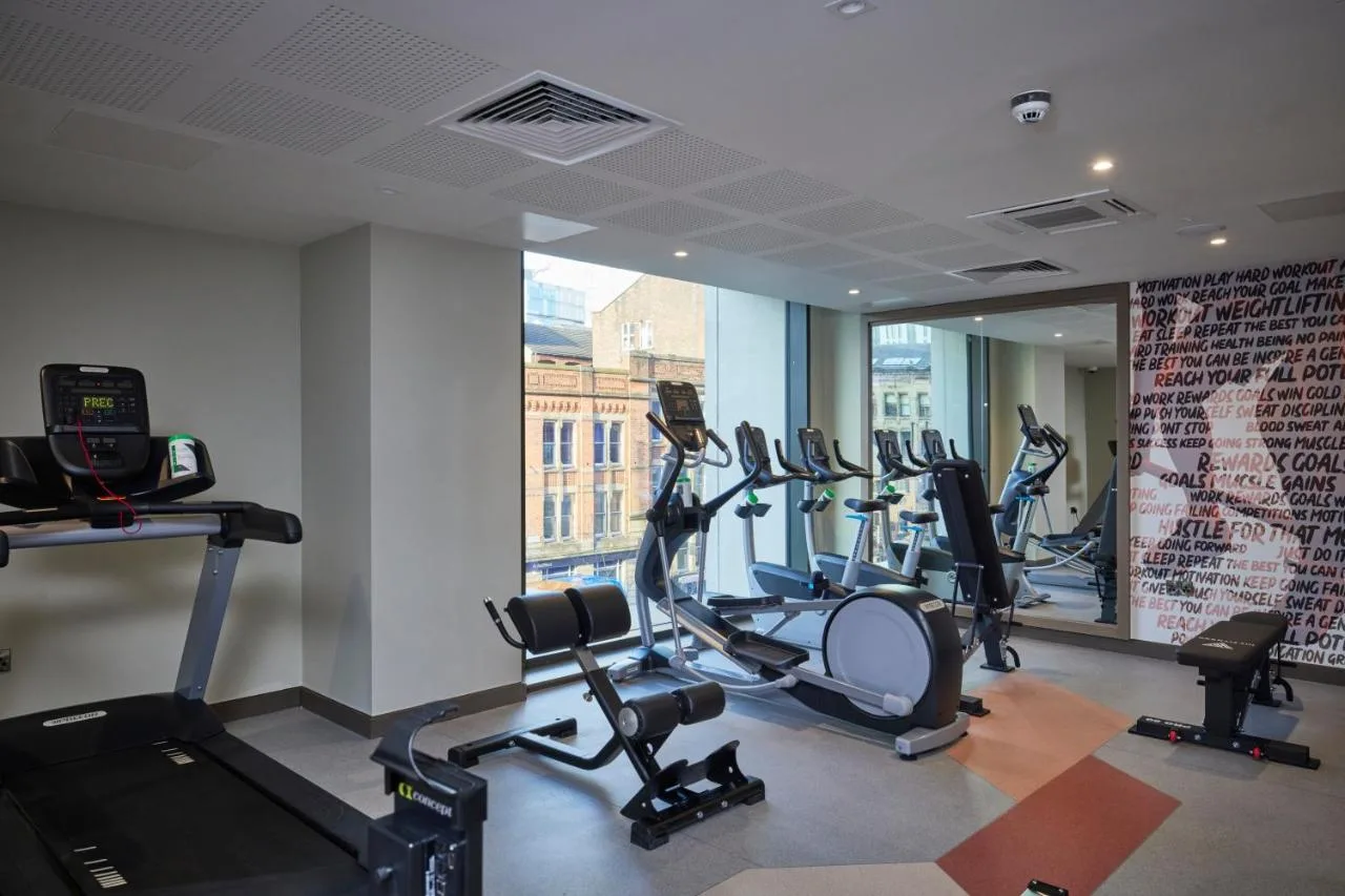 a gym with several treadmills and elliptical machines at Clayton Hotel Manchester City Centre in Manchester