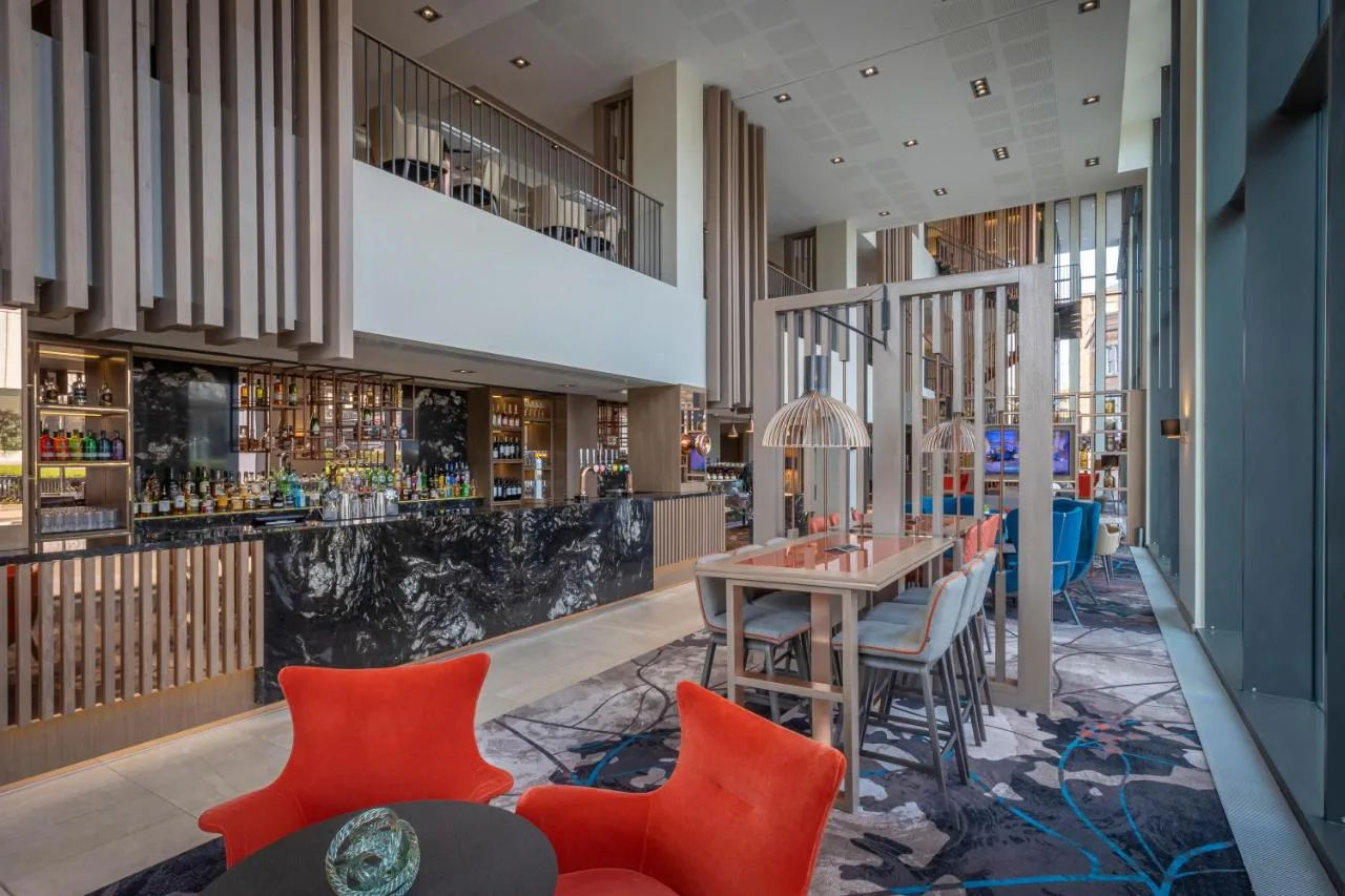 a rendering of a restaurant with orange chairs and a table at Clayton Hotel Manchester City Centre in Manchester